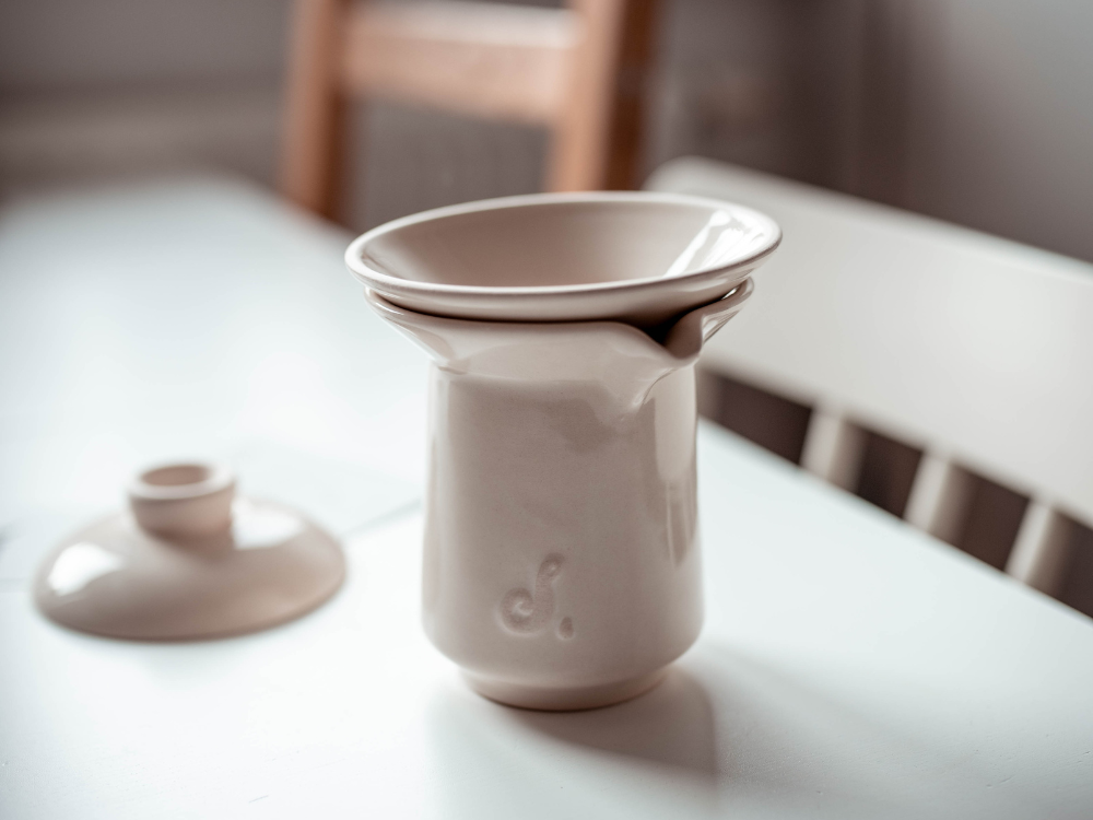 Ceramiczny zestaw do parzenia kawy przelewowej Slowpresso. Na zdjęciu widać ceramikę do parzenia kawy. Pokrywka, sitko i dzbanek na stole.