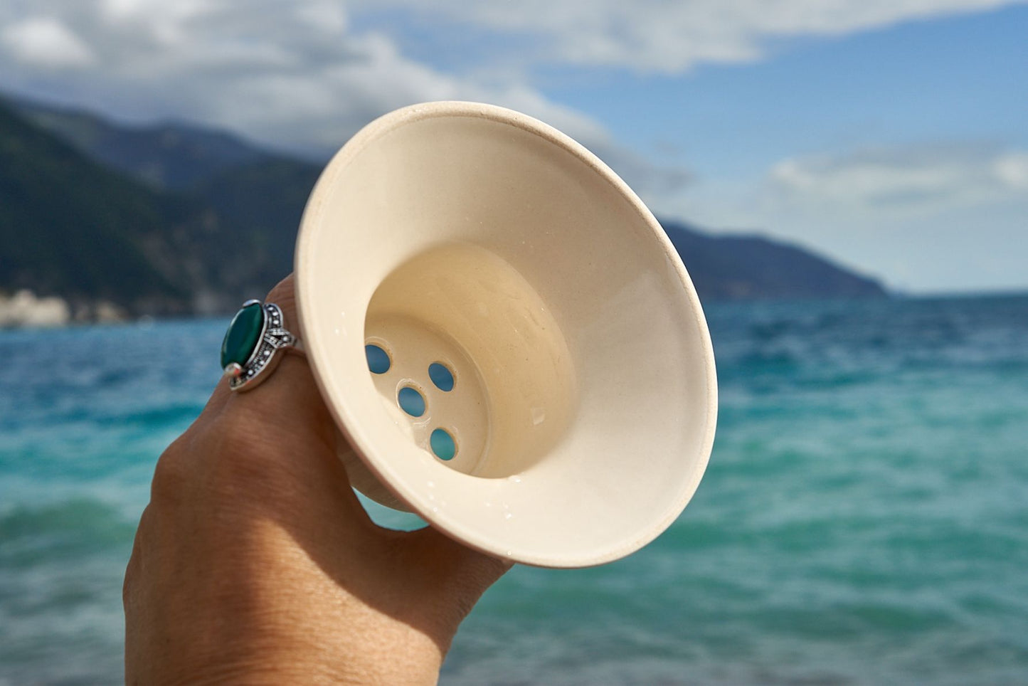 Ceramiczny zestaw do parzenia kawy przelewowej w podróży. Slowpresso GO trzymane w ręku na plaży