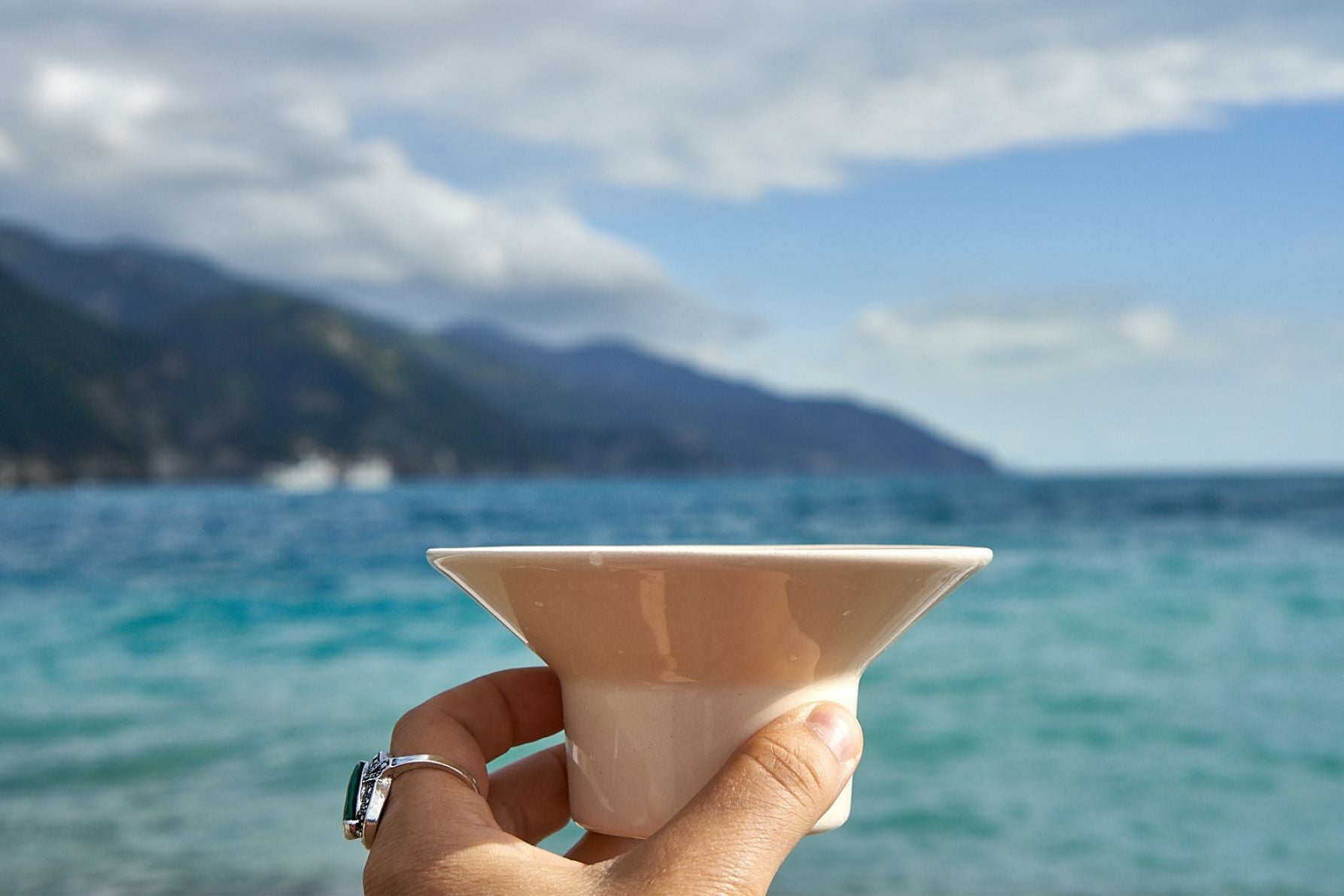 Ceramiczny zestaw do parzenia kawy przelewowej w podróży. Slowpresso GO w ręku widok z boku